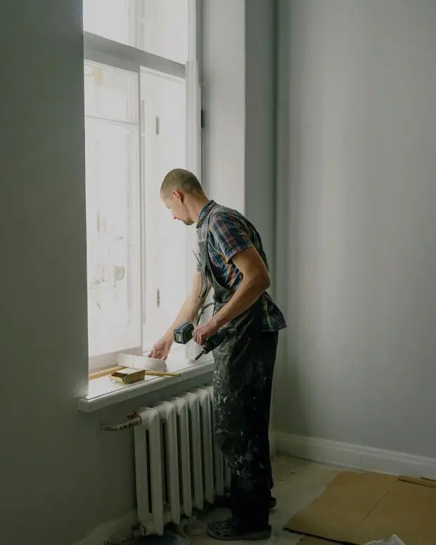 Artisan travaillant près d’une fenêtre dans un appartement